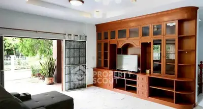 Spacious living room with elegant wooden cabinetry and garden view