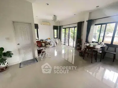 Spacious living room with large windows and modern decor, perfect for family gatherings.