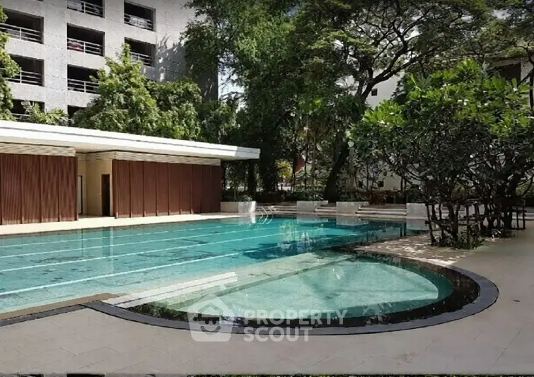 Luxurious outdoor pool area with lush greenery and modern architecture.