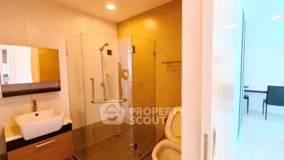 Modern bathroom with glass shower and stylish sink in contemporary home.