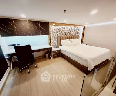 Modern bedroom with stylish decor and workspace, featuring a comfortable bed and sleek desk.