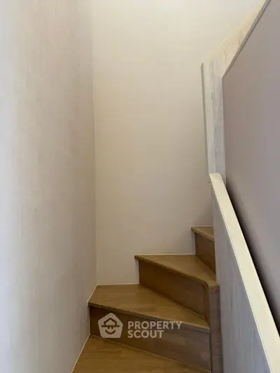 Modern wooden staircase with minimalist design and neutral tones