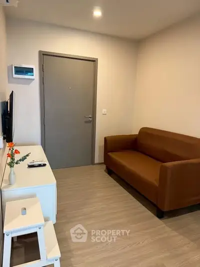 Cozy living room with modern brown sofa and sleek TV setup, perfect for relaxation.