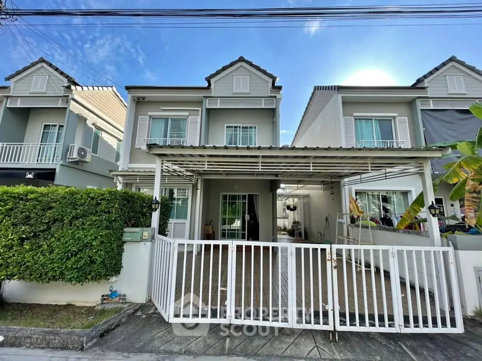 Charming townhouse with gated entrance and lush greenery in a serene neighborhood.