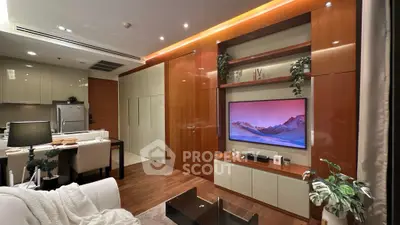 Modern living room with sleek wooden paneling and integrated TV unit, open kitchen layout, and elegant decor.