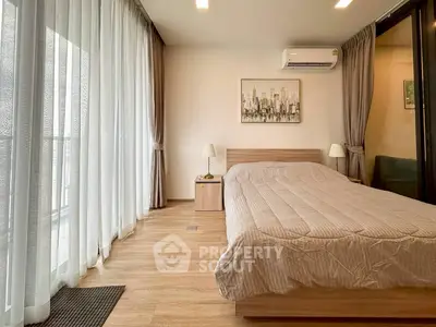 Spacious bedroom with modern decor and large windows for natural light.
