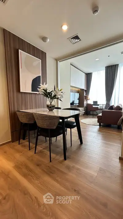 Modern open-plan living and dining area with stylish decor and wooden flooring.
