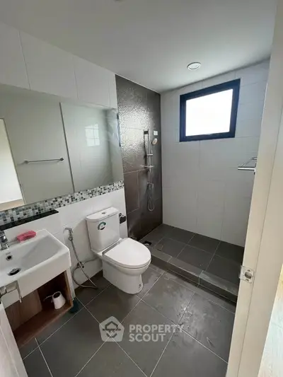 Modern bathroom with sleek design, featuring a walk-in shower and contemporary fixtures.