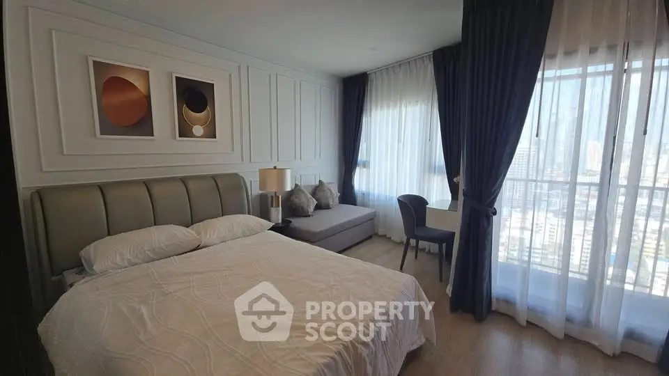 Luxurious bedroom with city view, elegant decor, and natural light.