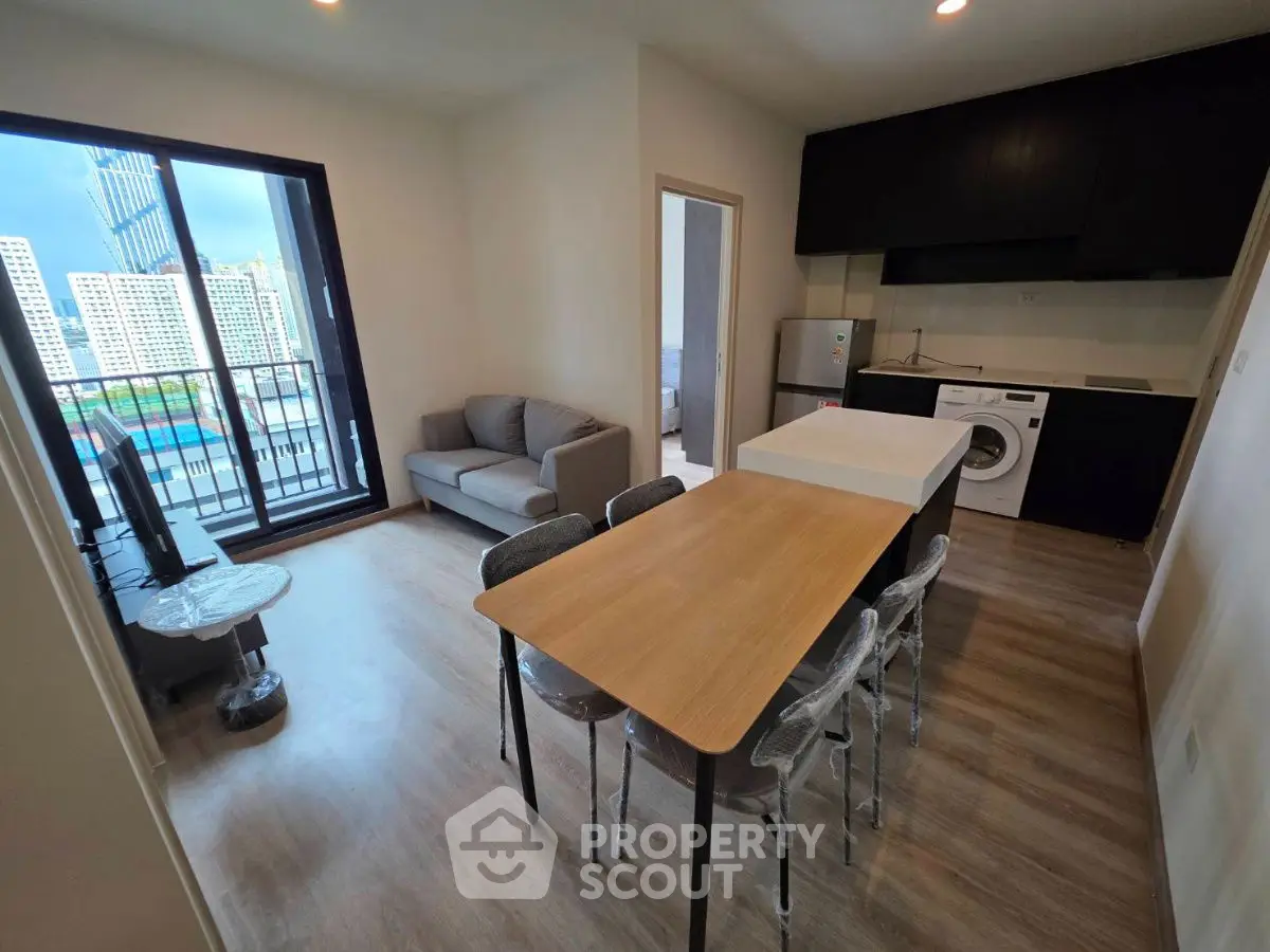Modern apartment with open layout, featuring a cozy living area and kitchen with city view balcony.