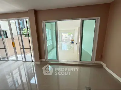Spacious modern living room with large windows and glossy tiled floors, perfect for natural light lovers.