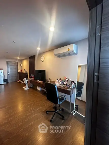 Spacious modern living room with sleek wooden flooring and stylish furniture, perfect for urban living.