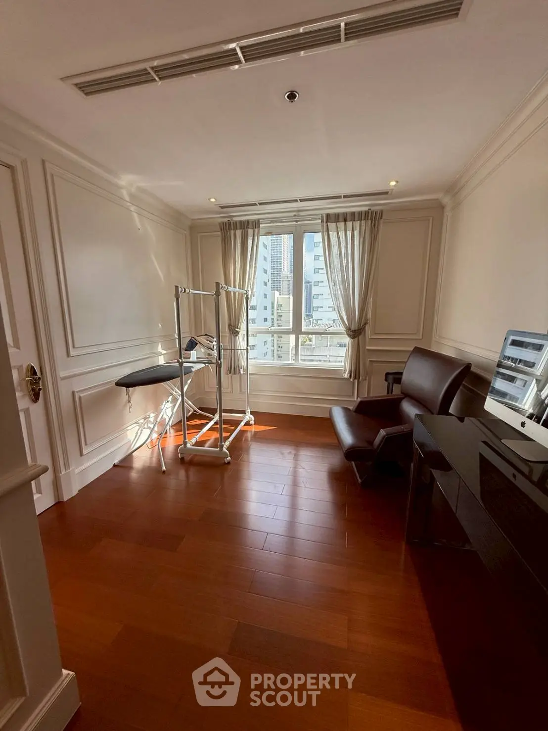 Elegant study room with hardwood floors and city view, perfect for productivity.