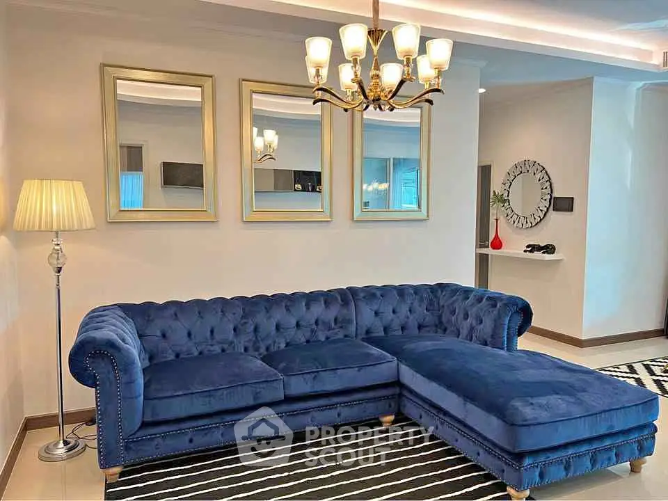 Luxurious living room with elegant blue velvet sectional sofa and stylish decor.