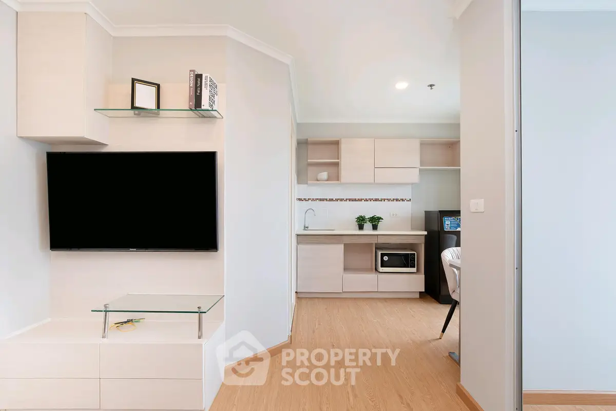 Modern living room with sleek TV setup and open kitchen layout