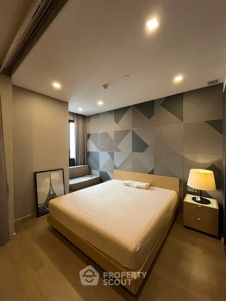 Modern bedroom with geometric accent wall and cozy lighting