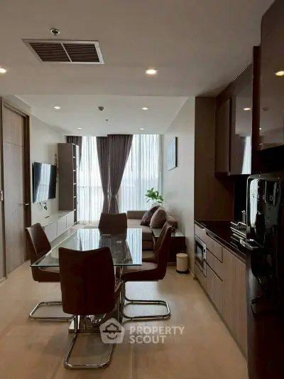 Modern open-plan living room and kitchen with sleek furniture and natural light.