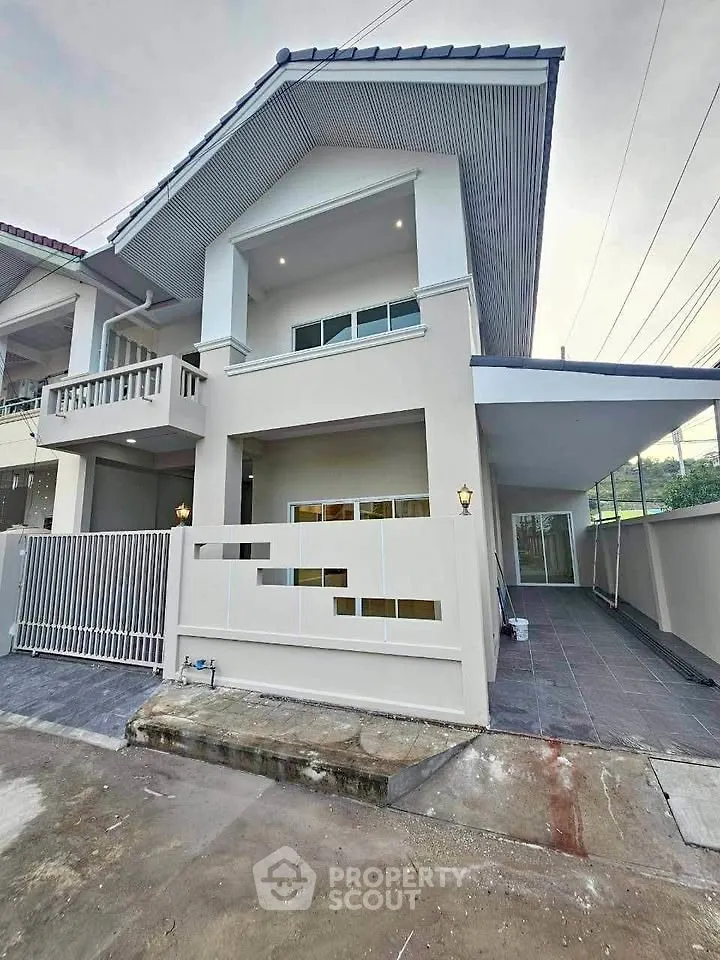 Modern two-story house with sleek design and spacious driveway in a suburban neighborhood.