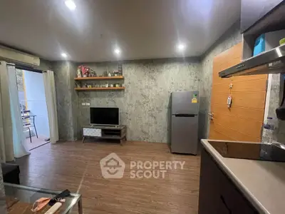 Modern living room with sleek design, featuring a TV, fridge, and stylish decor.