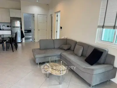 Spacious living room with modern gray sectional sofa and open kitchen layout