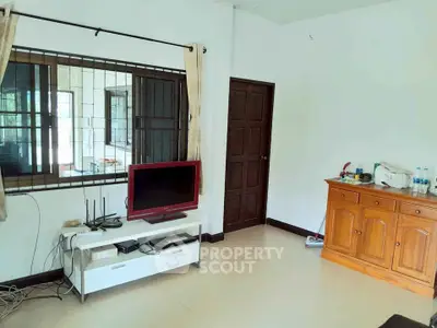 Cozy living room with TV and wooden cabinet, perfect for relaxation.