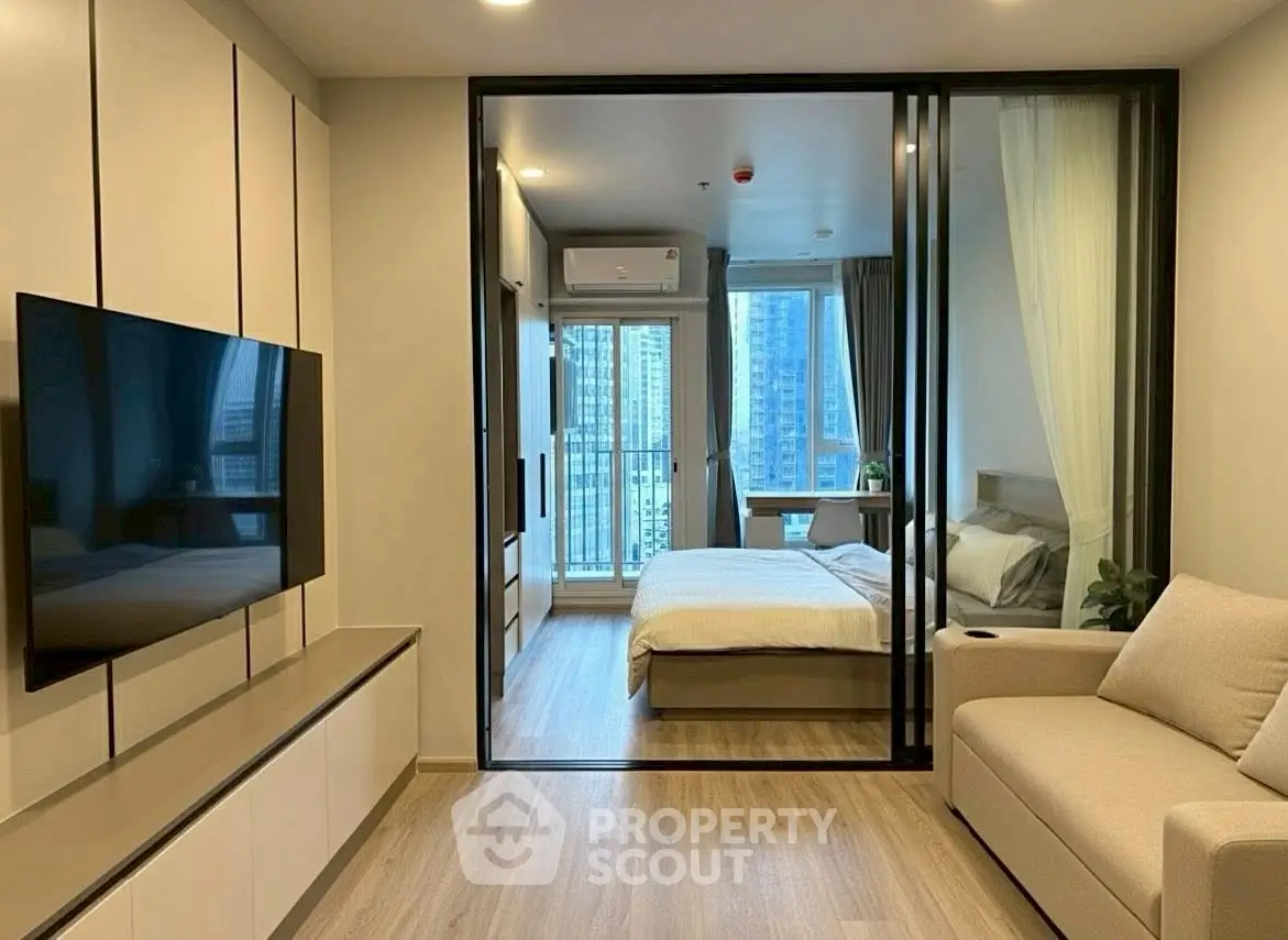 Modern apartment interior with glass partition, cozy living area, and stylish bedroom.