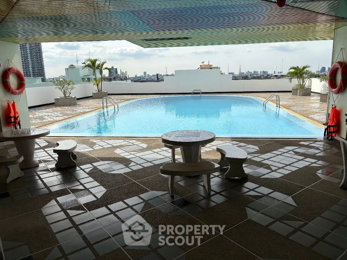 Luxurious rooftop pool with stunning city skyline views and modern seating area.