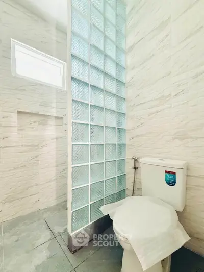 Modern bathroom with glass block partition and sleek tile design