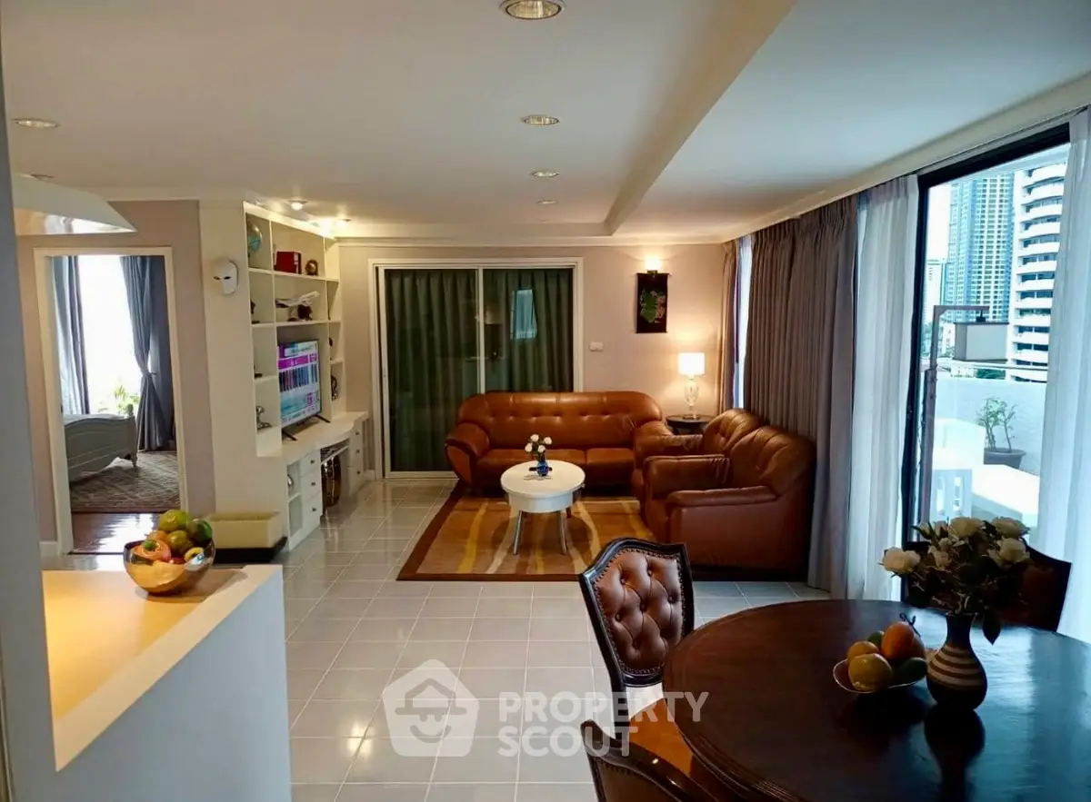 Spacious living room with modern decor and city view balcony access.