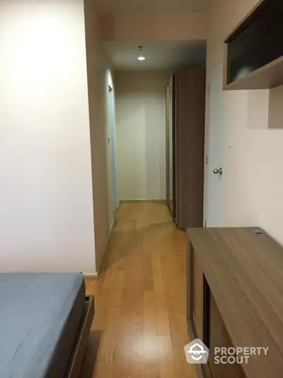 Modern apartment hallway with wooden flooring and sleek storage solutions.