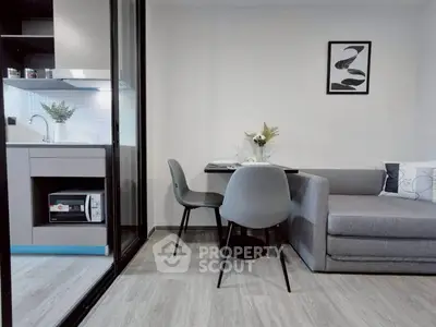 Modern compact living room with sleek kitchen and cozy dining area, perfect for urban living.