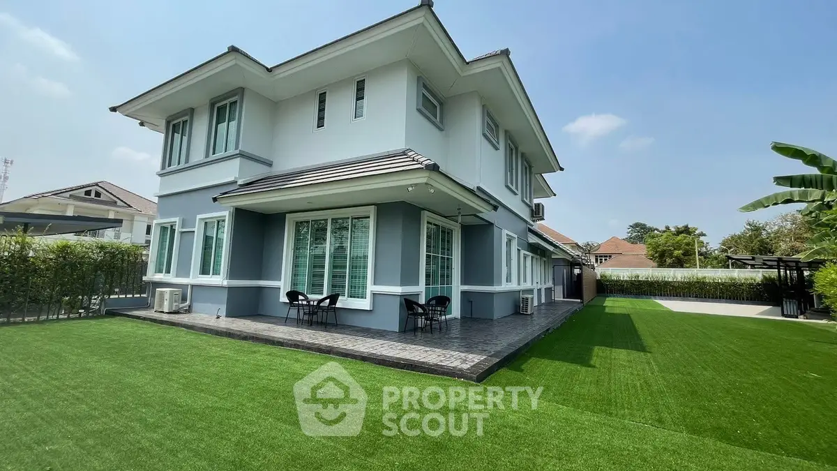 Stunning modern two-story house with lush green lawn and elegant exterior design.