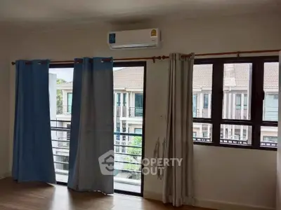 Spacious living room with large windows and balcony access in modern apartment.