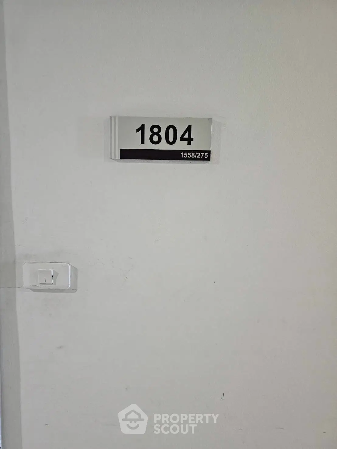 Modern apartment unit number 1804 on a white wall, indicating a stylish urban living space.