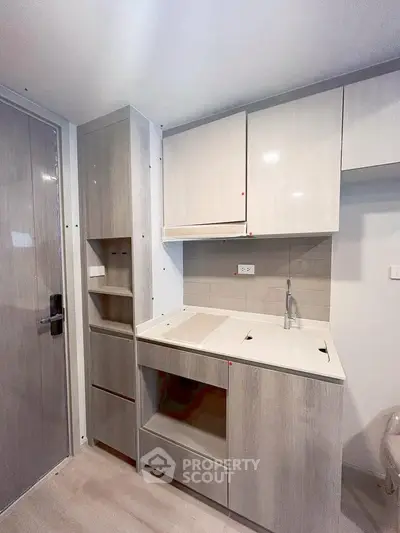 Modern compact kitchen with sleek cabinetry and integrated appliances in a stylish apartment.