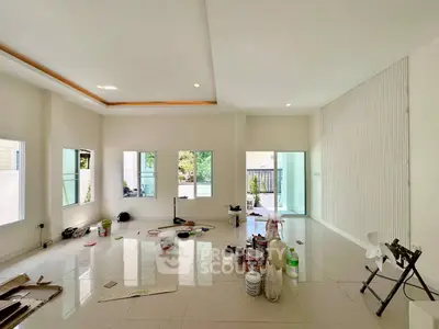 Spacious living room with large windows and modern design, perfect for natural light and open space.