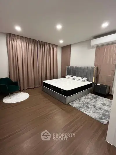 Spacious modern bedroom with elegant decor and large windows.