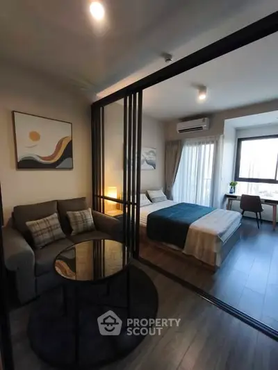 Modern studio apartment with cozy living area and stylish bedroom, featuring elegant decor and natural light.