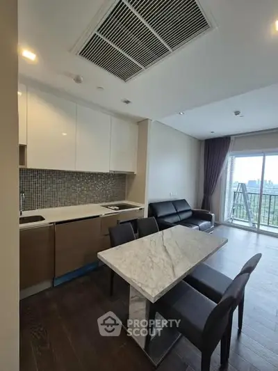 Modern open-layout kitchen and living room with balcony view in stylish apartment.