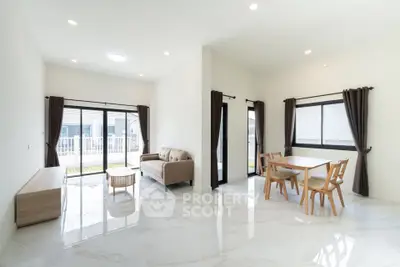 Spacious modern living room with elegant dining area and large windows.