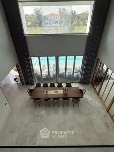 Luxurious dining area with high ceilings and pool view, perfect for elegant gatherings.