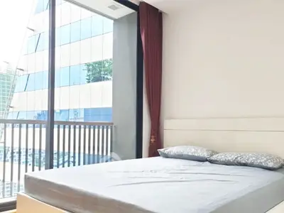 Modern bedroom with large window offering city view in high-rise apartment