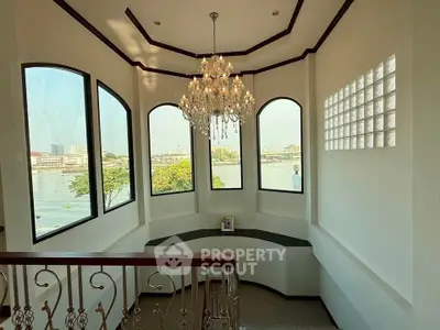 Elegant staircase with chandelier and panoramic river view