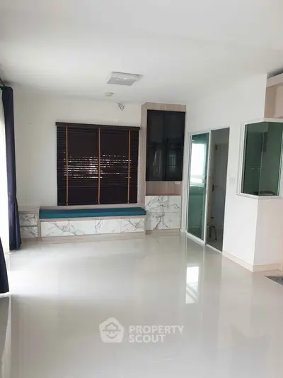 Spacious modern living room with marble accents and large windows for natural light.