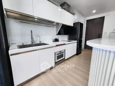 Modern kitchen with sleek white cabinetry and built-in appliances in a stylish apartment.