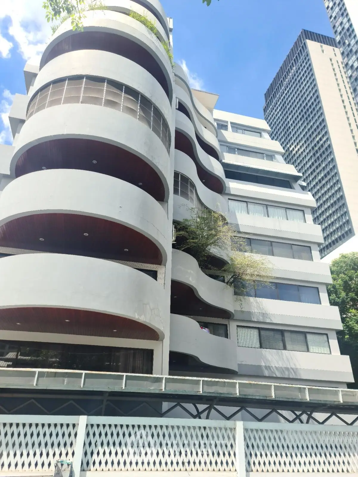Stunning modern apartment building with unique curved balconies and sleek design in urban setting.