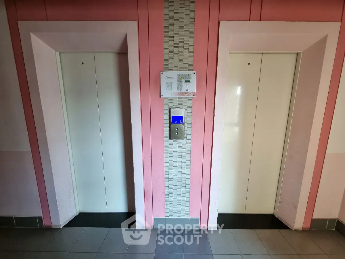 Modern building elevator lobby with dual elevators and stylish wall design.