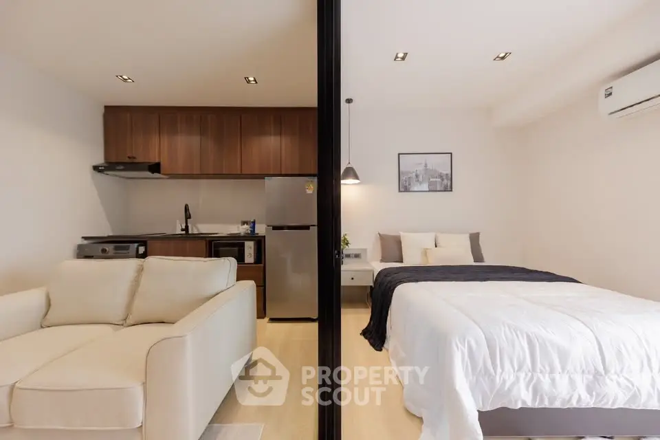 Modern studio apartment with open layout, featuring cozy living area and stylish kitchen.