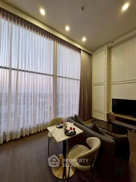 Luxurious high-ceiling living room with elegant decor and panoramic windows.