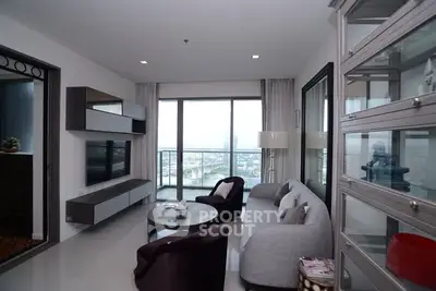 Modern living room with large windows and stylish furniture in a high-rise apartment.